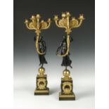 A pair of early 19th century French ormolu and bronze candelabra, each cast as a Classical maiden