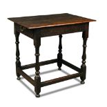 An oak side table, late 17th century, with a patinated plank top, end drawer, on stretched turned