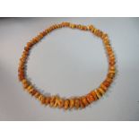 A graduated butterscotch amber necklace, the polished 'pebbles' of varying shape, colour and