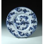 An 18th century Dutch Delftware blue and white charger, decorated in the chinoiserie manner with