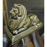 A Poole (Carter's Tiles) retailer's gift figure of a reclining lion