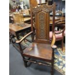 An 18th century carved oak open armchair with panel seat