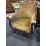 A 19th century mahogany tub armchair with outswept arms on turned front legs and brasses on castors