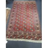 A red ground Bokhara rug, 220 x 130cm together with another similar (2)