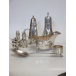 A silver sugar sifter and another, a sauceboat, silver oil burner, salt and pepper, table spoon