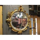 A circular mirror, 60 cm diameter, in a decorative gilt frame
