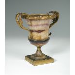 A 19th century gilt mounted blue john urn, the flared rim with scrolling gilt mount and foliate cast