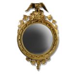 A 19th century gilt framed convex mirror, with eagle cresting, laurel leaf and berry swags, plate