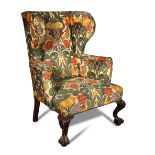 A George II style mahogany wing armchair, upholstered in 'Gainsborough' woven fabric, on dwarf