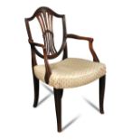 A George III mahogany Hepplewhite style elbow dining chair, with a carved wheatsheaf back, to a