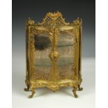 A 19th century gilt brass table vitrine, the bombé fronted cabinet with pierced scroll work and