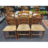 Eight rush seated ladder back dining chairs