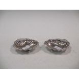 A pair of silver shell moulded butter dishes