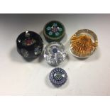 Five Perthshire glass paperweights, comprising a limited edition overlay bouquet weight, a