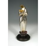 A silvered and gilt bronze stylised figure of the Madonna, unsigned, mounted to a turned wooden base