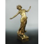 A gilt bronze figure of a lady signed M. Piere, her arms raised and bare chested, raised on a