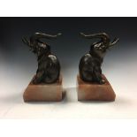 A pair of Art Deco bronzed elephant bookends, each modelled seated, their trunks in salute,