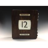 An Art Deco perpetual wall calendar, plywood cased with day, date and month printed to canvas