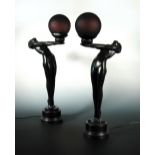 A pair of Art Deco style figural bronzed table lamps, each as a female nude standing on tiptoes