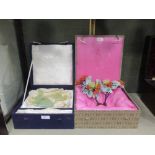 A brocade boxed Chinese bowenite carving together with brocade boxed pair of floral candlsticks