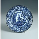 A 17th century Kraak blue and white plate, centrally painted with a bird on a rock between flowers