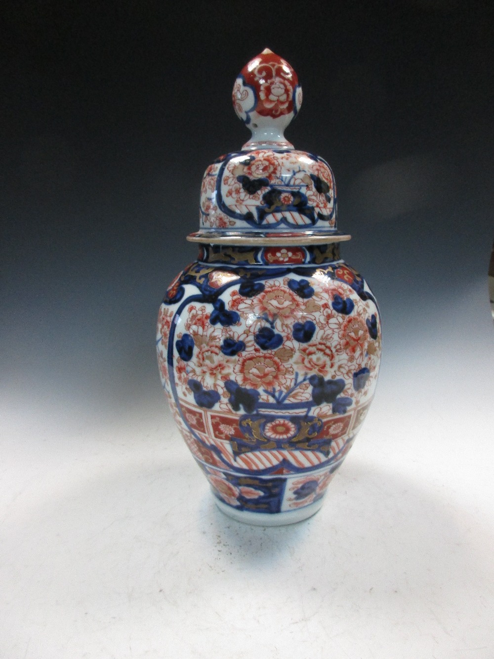 A late 19th/early 20th century Imari jar and cover, the ovoid body painted with two blue framed