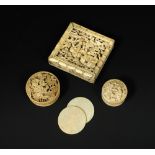 An ivory puzzle box, two counter boxes with counters, the boxes carved in relief with village