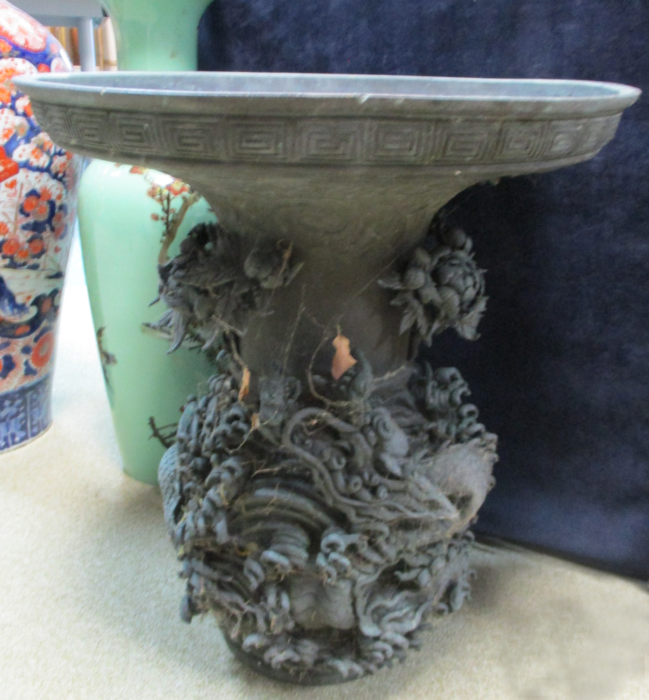 A 19th century bronze vase, the broad flared rim above a baluster body cast in high relief with a