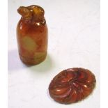 An amber thimble shaped finial and a plaque, the domed top of the finial carved with a toad, its rim