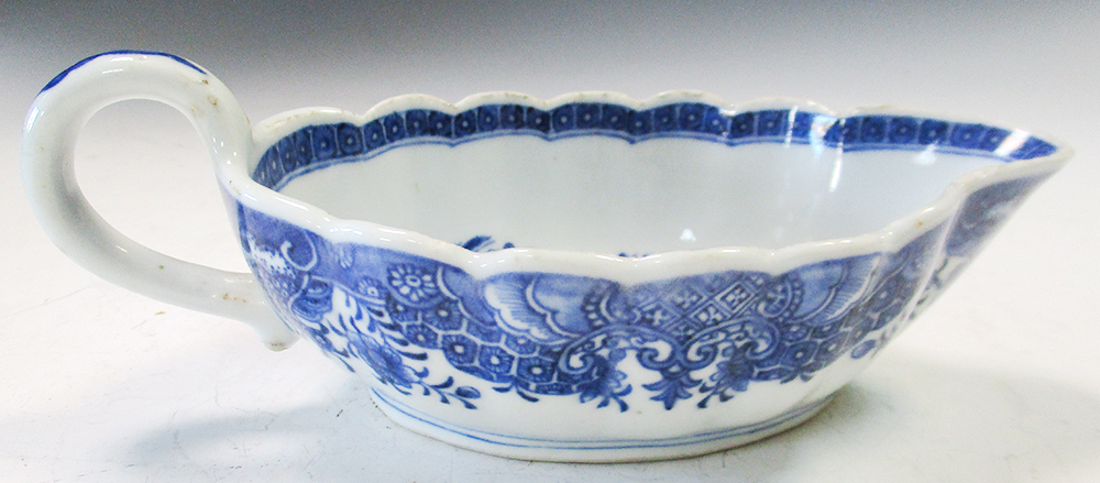 An 18th century blue and white sauce boat, the fluted rim with corallite band enclosing a scene