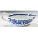 An 18th century blue and white sauce boat, the fluted rim with corallite band enclosing a scene