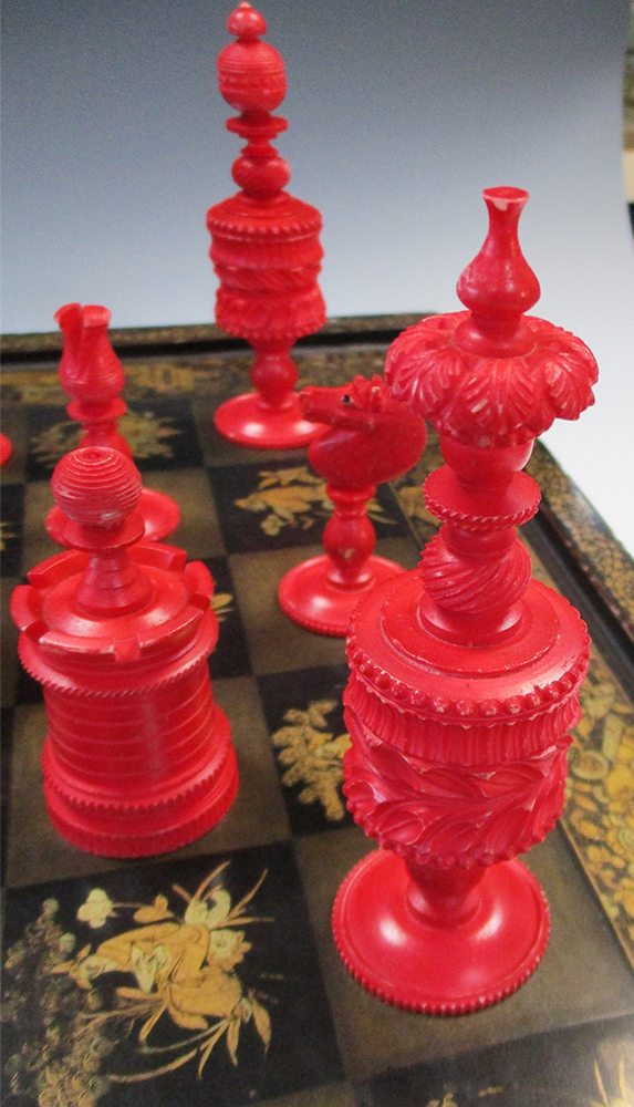 A 19th century red and white bone chess set together with a lacquer board, the dark squares of the - Image 3 of 6