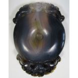 An agate bi pendant, the black stone with a white band running from the bat crest across the rounded