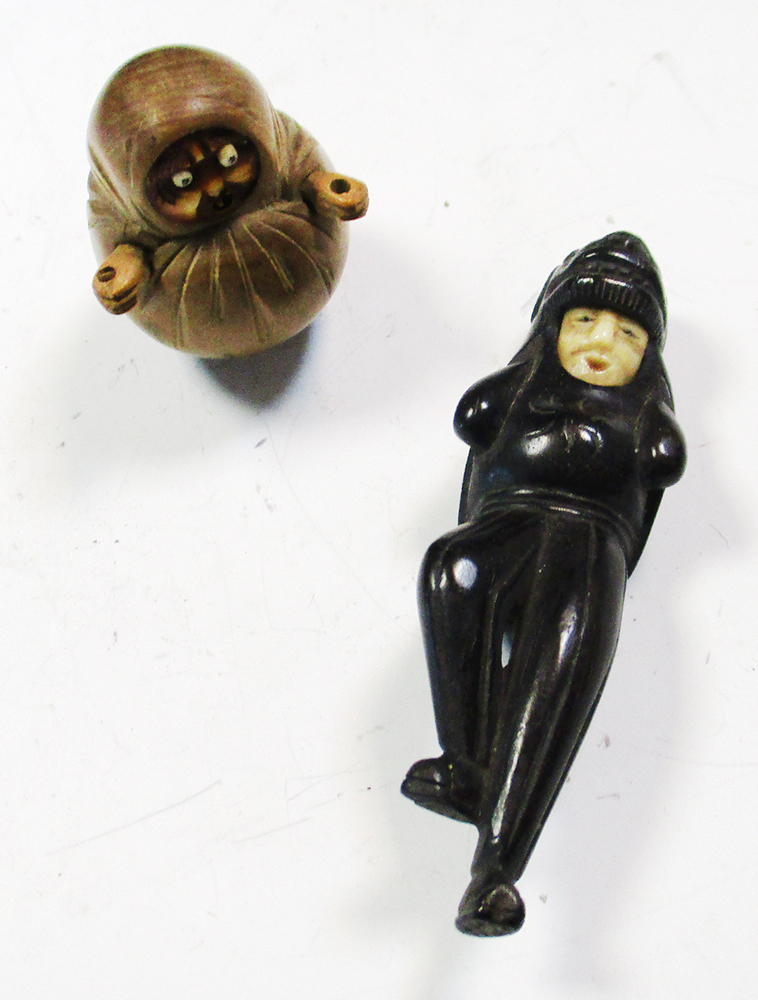 A Kobe Daruma toy and a lion masked man netsuke, the first depicting the monk wrapped in his