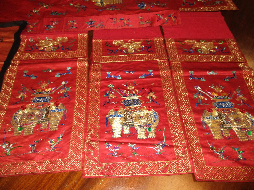 A set of four red silk panels and another, each of the set embroidered in gold thread with a - Image 2 of 4