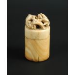 An 18th/19th century ivory cylindrical box seal, the screw top pierced and carved with two