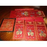 A set of four red silk panels and another, each of the set embroidered in gold thread with a