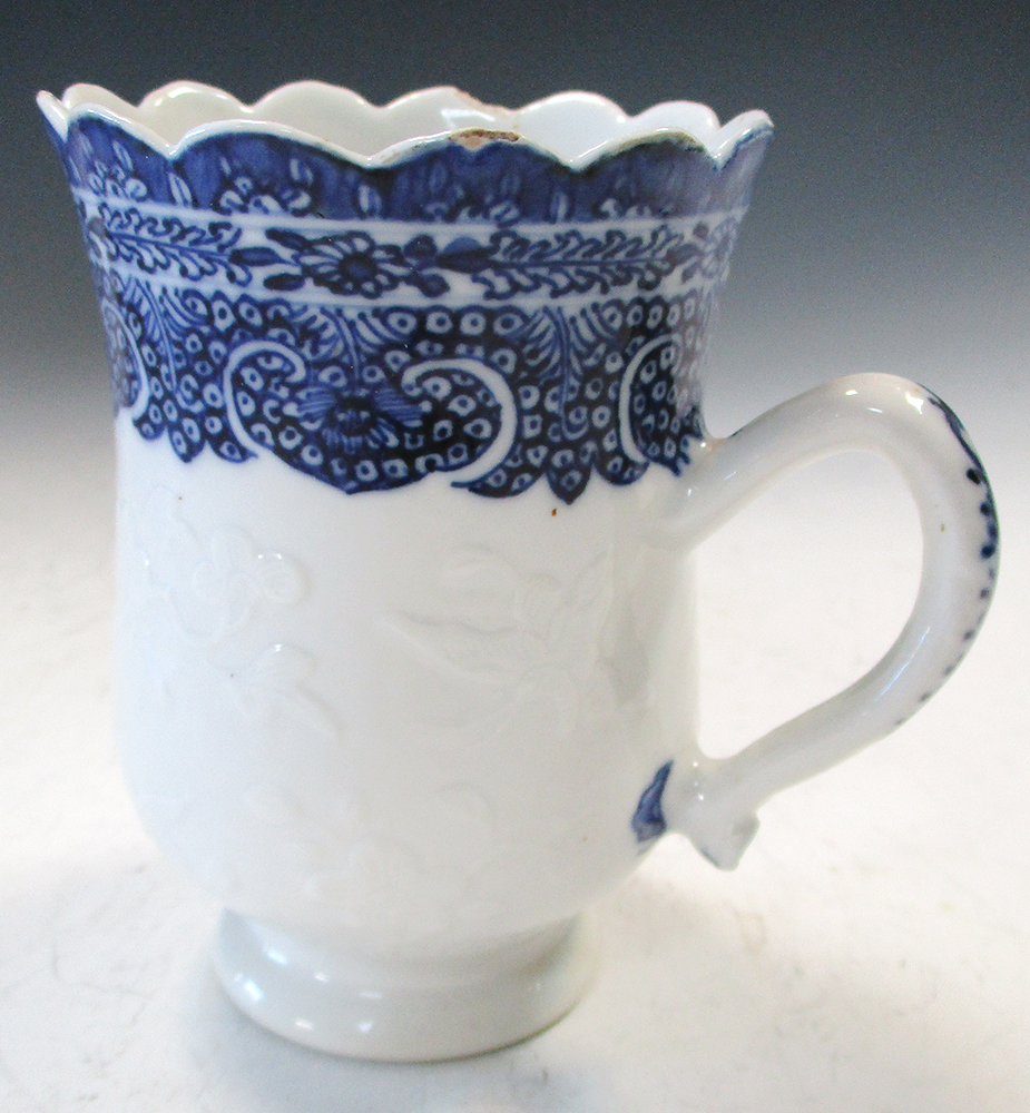 An 18th century blue and white mug, possibly soft paste, the bell shape painted with three