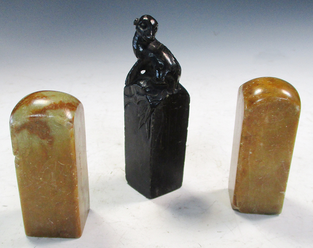 Three soapstone seals, the two similar seals of mottled toffee colour, of square section, with domed