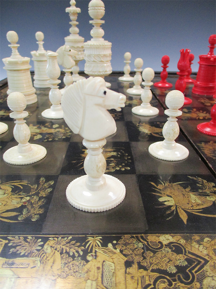 A 19th century red and white bone chess set together with a lacquer board, the dark squares of the - Image 2 of 6