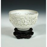 An early 17th century white glazed biscuit reticulated bowl, the exterior with four roundels of