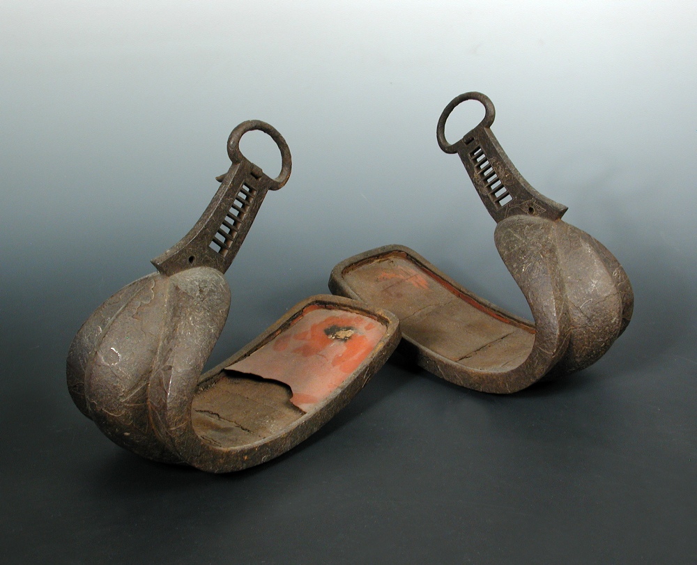 A pair of 17th/18th century stirrups, the crest curved toes running down from buckle attachments