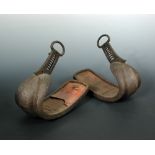 A pair of 17th/18th century stirrups, the crest curved toes running down from buckle attachments