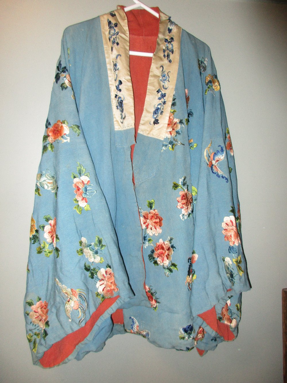 A late 19th/early 20th century turquoise silk jacket, embroidered with butterflies amongst scattered