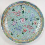 A 20th century turquoise ground dish, the alternating pink and blue dragons radiating about a