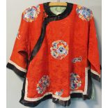 A child's black trimmed red silk damask jacket, embroidered in blues and gold thread with floral