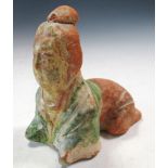 A Ming pottery figure of a lady lying on her front in sphinx like pose, her skin glazed yellow,
