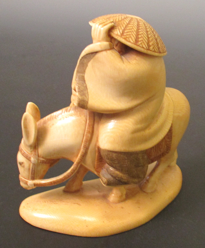 An early 20th century ivory figure of Fukurokuju riding a donkey with one hand on his straw hat - Image 2 of 4