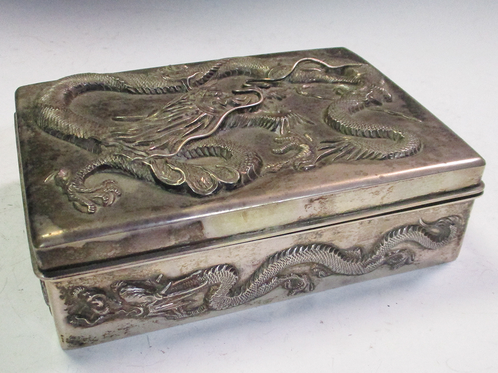 An early 20th century silver double cigarette box, the rectangular hinged lid and sides cast in