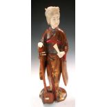 A late 19th/early 20th century lacquered wood and ivory figure of a lady standing with her right